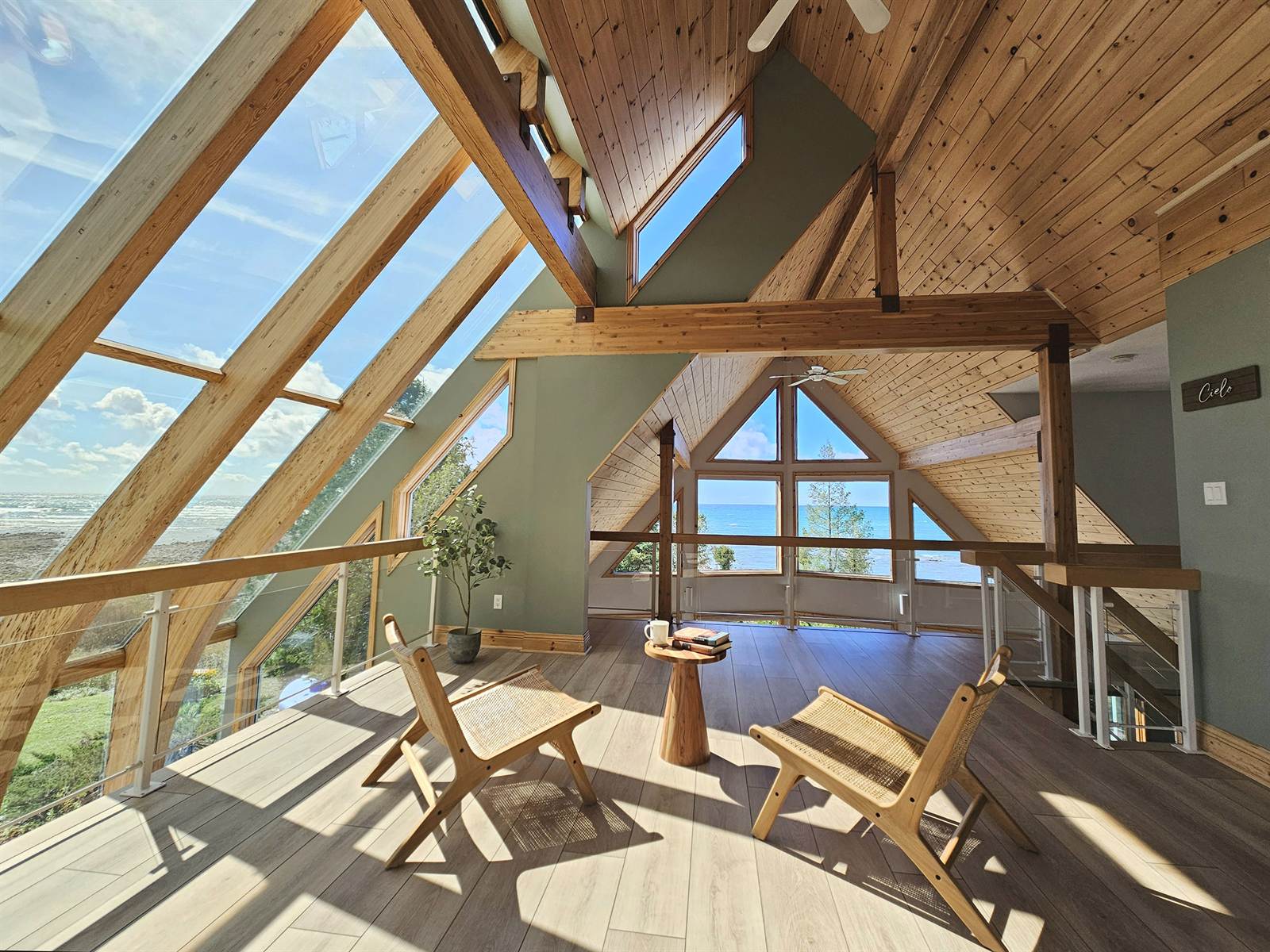 Cielo loft under the angled sky windows with rattan chairs and lake view