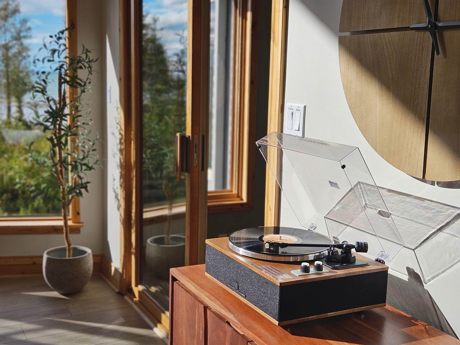 Record player in warm light by the sliding glass doors