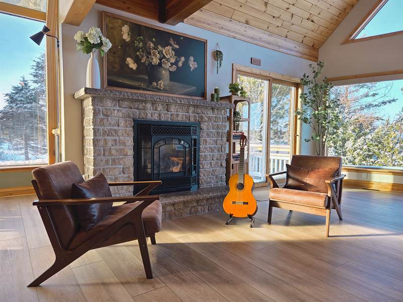 Fireplace with leather chairs and a guitar in winter light