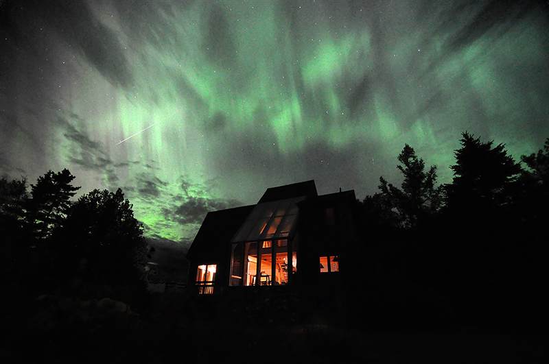 Aurora borealis and a shooting star over the cottage